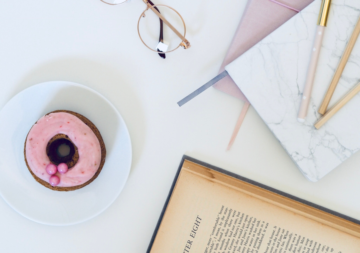 flatlay with a book, donut and planner for blogging