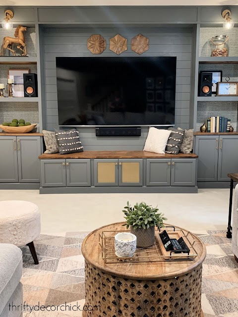 gray basement entertainment center with bench