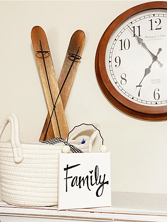 sign on a shelf with skis, a basket and a clock