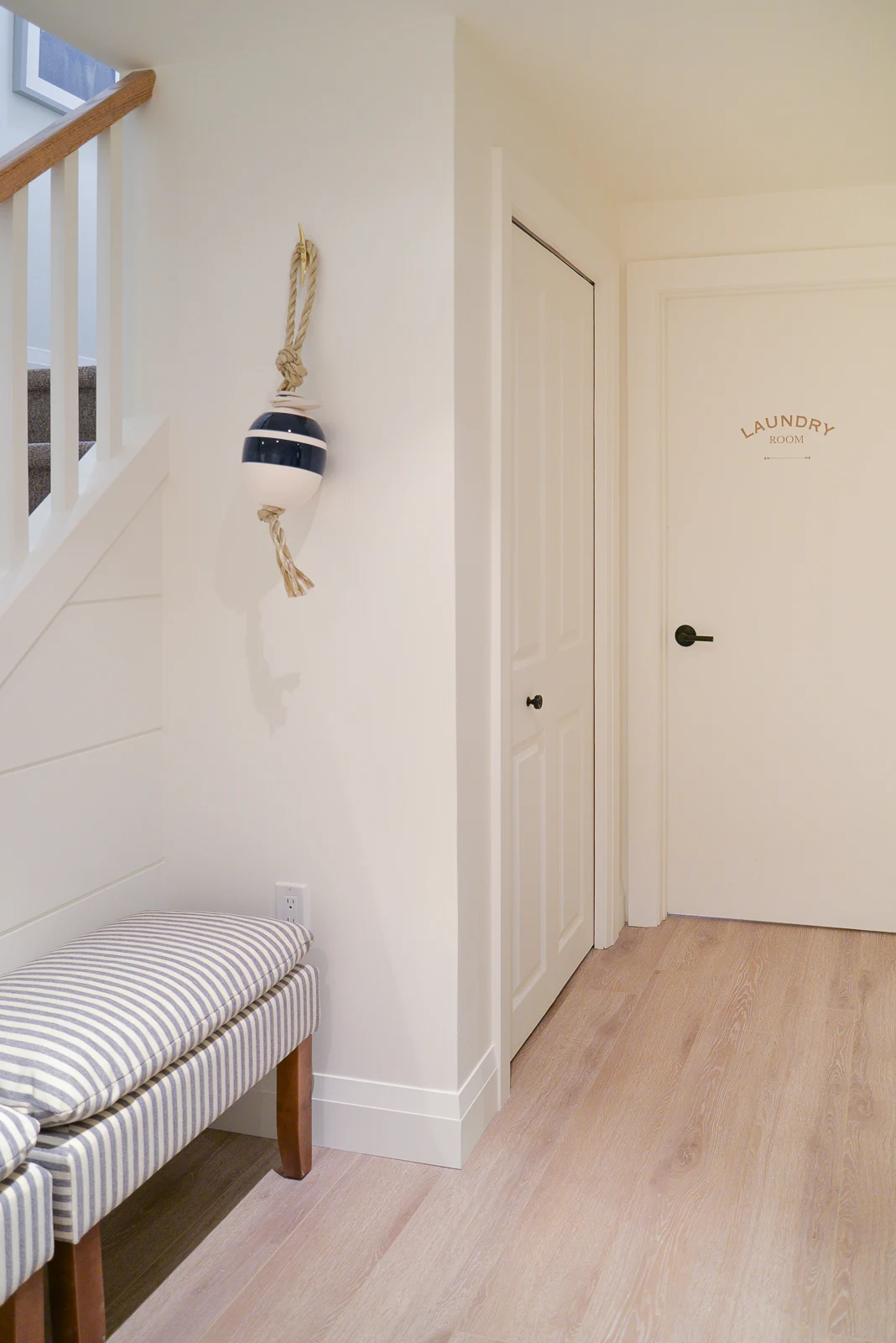 white basement walls with laundry room door decal and matte black handle