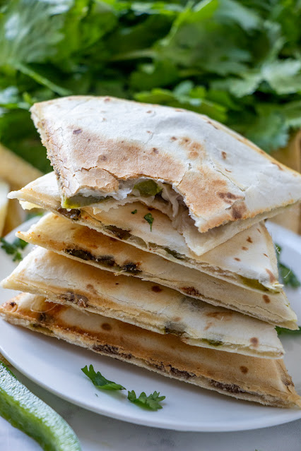 Philly Cheesesteak Quesadillas stacked and top one with bite mark