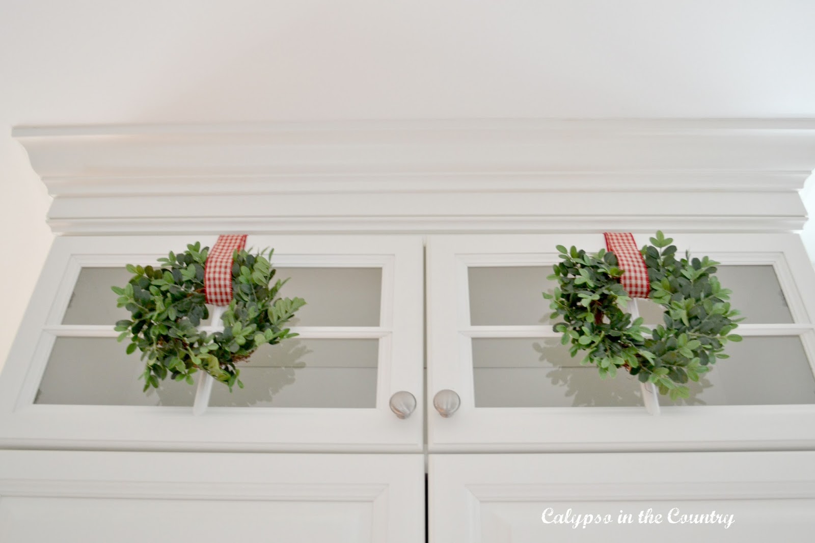 Glass Cabinets with mini wreaths Glass Stacked Cabinets with mini wreaths