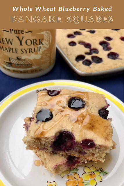 Baked blueberry pancake squares on a plate with maple syrup.