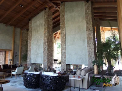 Pilares de pedra, com pedra moledo, na construção da lareira de pedra em sala de estar de residência em Piracaia-SP.