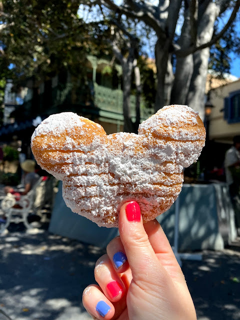 Holding the Mickey Beignet at New Orleans Square at Disneyland while wearing Essie Short Shorts and Deborah Lippmann A Wink And A Smile nail polishes.