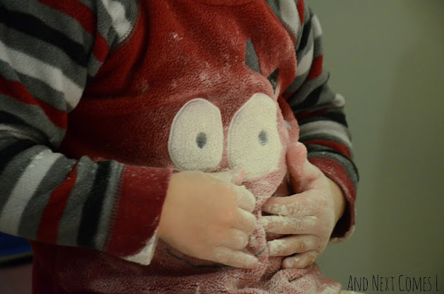 Toddler rubbing flour on their belly