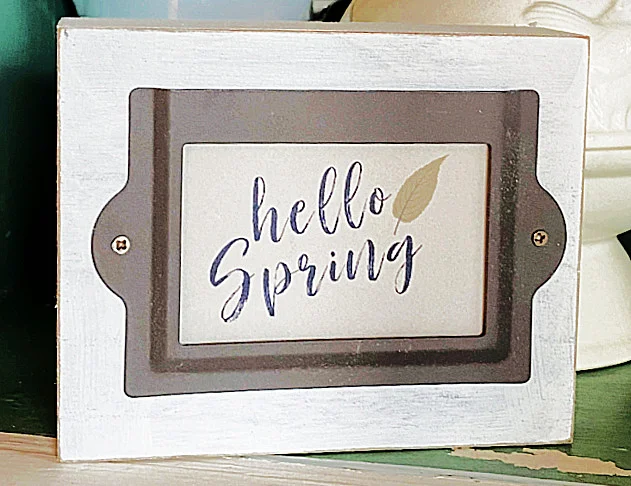 white sign with label and hello spring sign