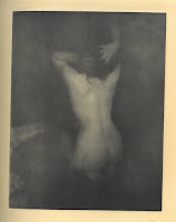 Photogravure of a nude woman kneeling with her back to the camera and her arms clutching her head