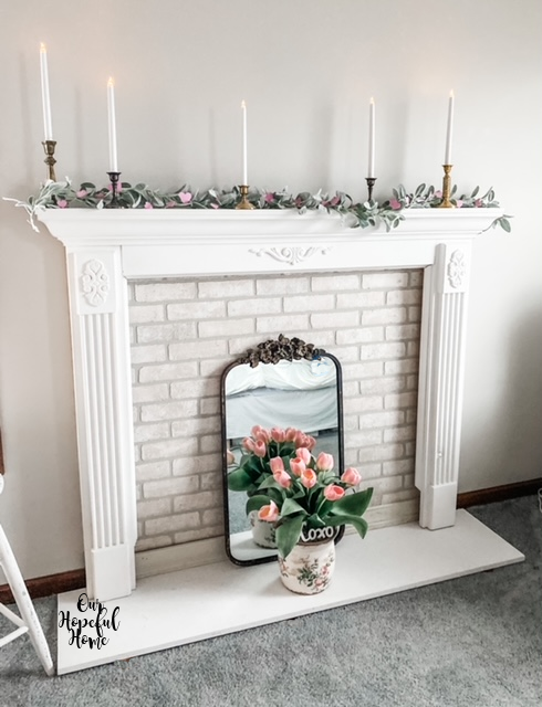 white fireplace mantel white taper candles brass candlesticks whitewashed brick facade