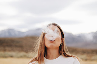 Woman with smoke coming out of her mouth