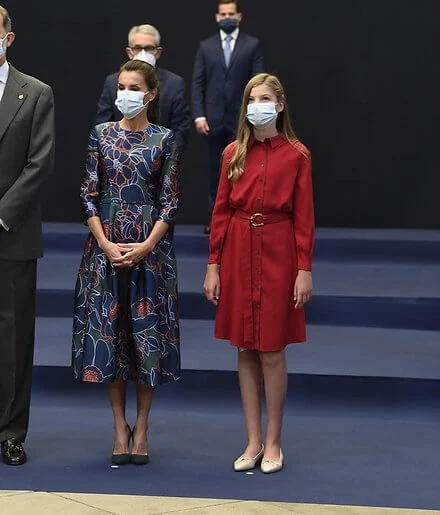 Queen Letizia wore a dress by Carolina Herrera. Crown Princess Leonor wore a print dress by Poeta. Infanta Sofia wore a red shirt dress by Mango