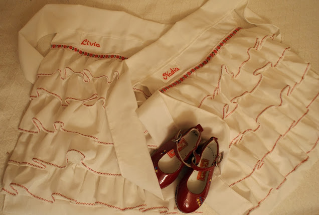 czerwone dziewczęce lakierki na białych fartuszkach z falbankami