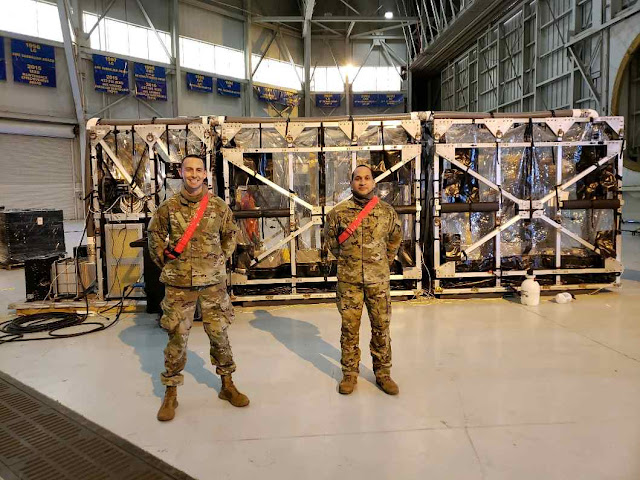 Dr. Daniel Adams and another team member standing next to the Transport Isolation System.