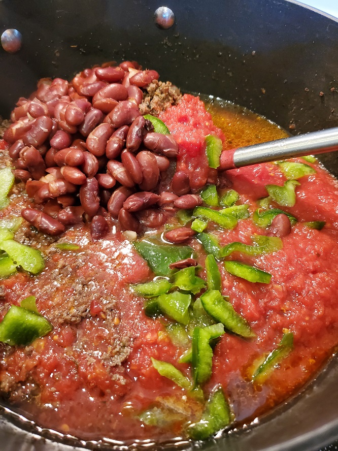 this is a pot of chili with green peppers and red kidney beans