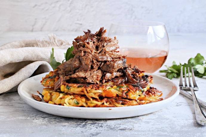 Recipe for a beef brisket, rubbed with mustard, liquid smoke and spices, wrapped and slow cooked in an oven and served over vegetable fritters.