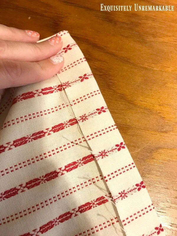 Red fabric folded to create a pocket for stitching