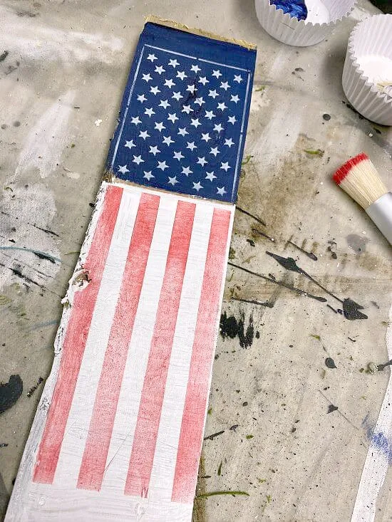 Stenciled red, white and blue flag on a wooden stake