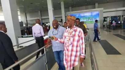Amaechi Minister takes off shoes at airport as Dele Momodu smiles behind him 
