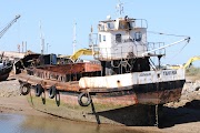 Rusted fishing boat on a river bank