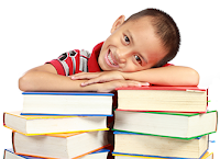 young boy leaning on stack of books