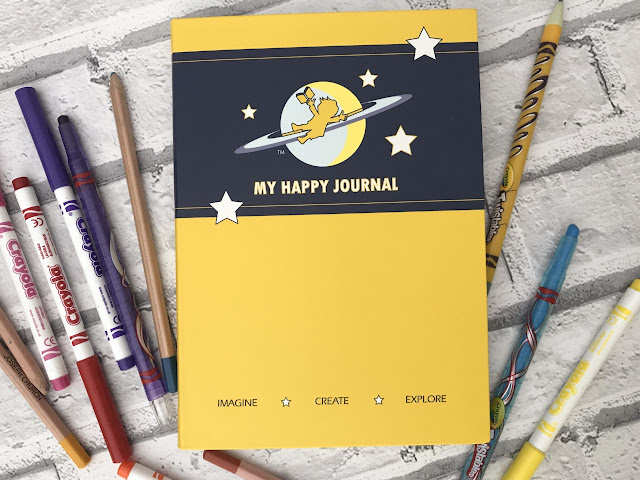 A bright yellow journal surrounded with pencils and crayons