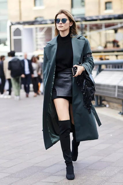 A petite girl wears a boot and coat.