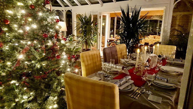 The conservatory at North Cottage Cromer decorated with lit tree and table set for celebration Christmas and New Year 2020.