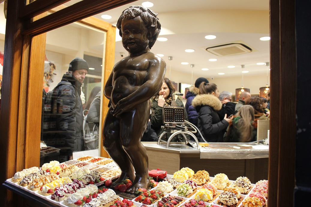 čurající chlapeček ve vitríně obchodu s waflema v Bruselu
