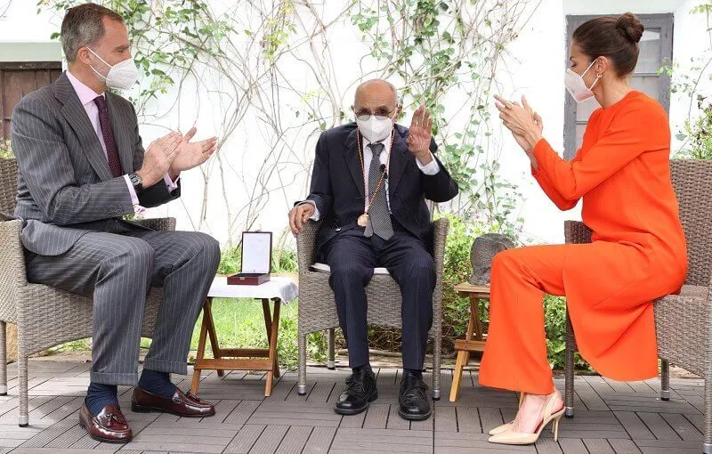 Queen Letizia wore an orange asymmetric outfit from Zara, and she carried red clutch by Angel Schlesser