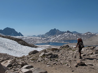 Eine zähe PCT Thru-Hikerin macht sich an den Abstieg ins Evolution Basin; im Hintergrund Wanda Lake