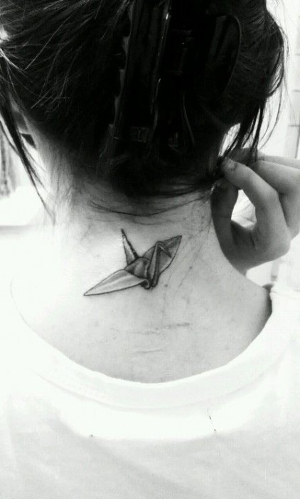 Chica con un tatuaje en la nunca en forma de ave de origami