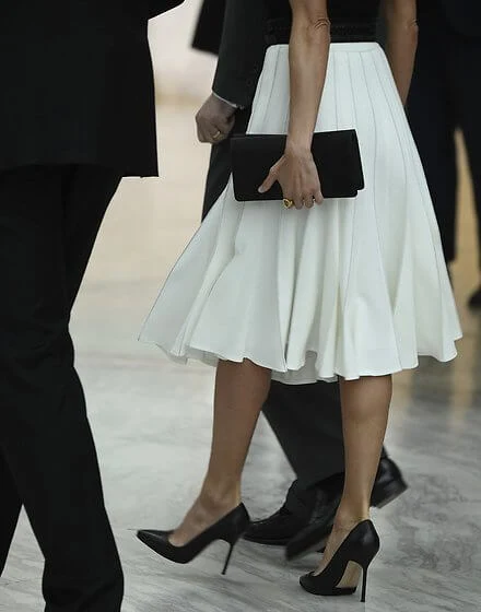 Queen Letizia wore a new white pleated skirt from Adolfo Dominguez, and black leather pumps from Manolo Blahnik, and belt from Burberry