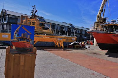 Plein air oil painting of Port Authority workboat 'Millers Point' being lifted by crane next to Moore's Wharf painted by marine Artist Jane Bennett