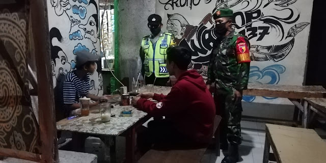 Mojokerto, - Personel Koramil 0815/05 Gedeg Kodim 0815/Mojokerto bersama anggota Polsek Gedeg menggelar patroli di sejumlah warung kopi (Warkop) di Desa Gedeg Kecamatan Gedeg Kabupaten Mojokerto, Jawa Timur, Selasa (16/06/2020) malam.  Patroli gabungan ini dilakukan dalam rangka memonitoring situasi dan kondisi para pengunjung warung kopi sekaligus memperketat penerapan protokol kesehatan Covid-19.  Tak hanya monitoring, patroli gabungan ini juga memberikan himbauan dan arahan kepada pengunjung agar selalu melaksanakan protokol kesehatan dengan cara sering cuci tangan pakai sabun, mamakai hand sanitizer, memakai masker dan menjaga jarak aman di antara pengunjung.  Di tempat terpisah, Danramil 0815/05 Gedeg Kapten Infanteri Mulyono, saat dikonfirmasi, membenarkan adanya kegiatan patroli tersebut. Menurutnya patroli tersebut bertujuan untuk memutus rantai penyebaran Covid-19.   “Dengan patroli di sejumlah warung kopi dan tempat keramaian lainnya, merupakan salah satu cara untuk memantau secara langsung apakah para pengunjung sudah menerapkan protokol kesehatan atau belum, seperti tertib cuci tangan dan mengenakan masker, jika masih ditemukan ada yang tidak mengenakan masker tentunya akan kami tegur,” ungkapnya.  Ditambahkan Babinsa Koramil 0815/05 Gedeg Pelda Rusmanto, tingkat kesadaran masyarakat sudah meningkat, terbukti saat melaksanakan patroli bersama di sebuah warung kopi, ternyata masyarakat sudah mengenakan masker, cuci tangan dan jaga jarak aman. (Jayak)