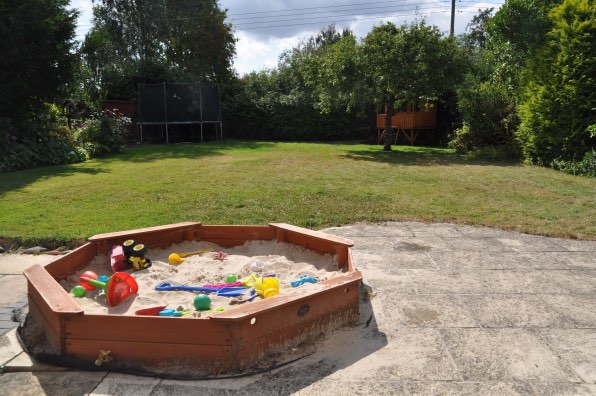 Morgan's Milieu | Home Exchange Membership Giveaway: Photo of a back garden with a playhouse and sandpit.