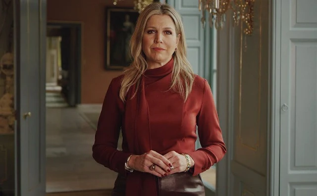 Queen Maxima wore a burgundy stretch scarf collar silk crepe blouse from Natan. burgundy faux leather skirt