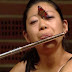 Borboleta pousa na testa de flautista, que se mantém imperturbável