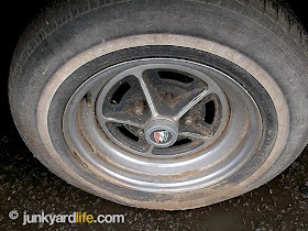 1977 Buick Regal wears four factory rally rims in the scrap yard.