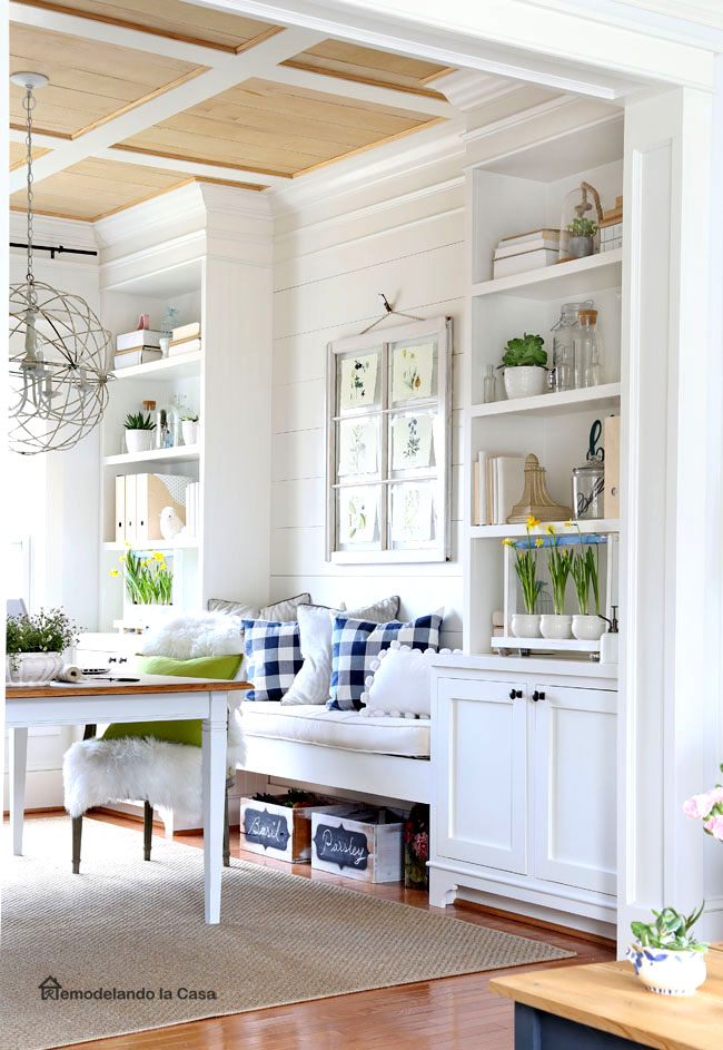 build-ins with spring decor with plants, clear glass bottles and plaid pillows on bench
