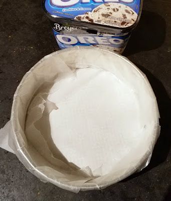 wax paper lined springform pan next to quart of ice cream