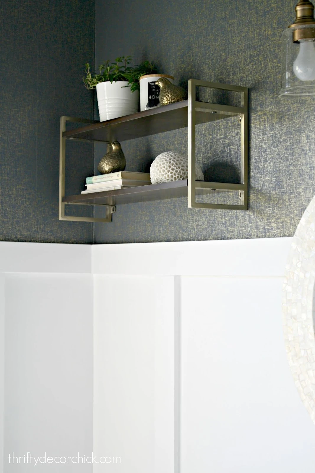 Wood and brass shelves above toilet
