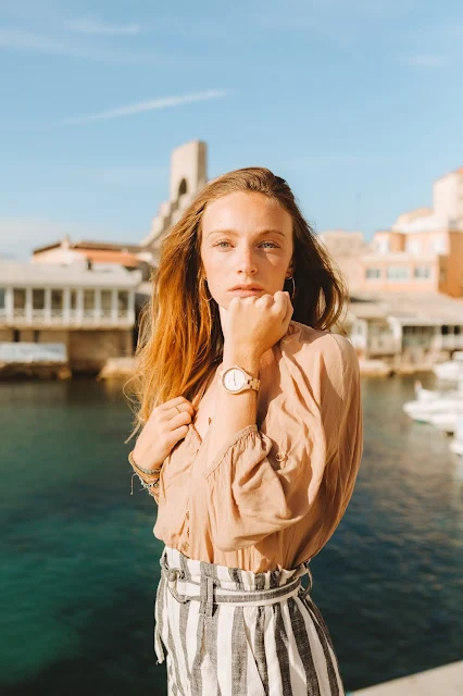 stunning woman with red hair looking to distance with watch on her wrist