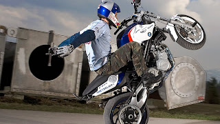 Foto met motorrijder die een kunstje laat zien op achterwiel