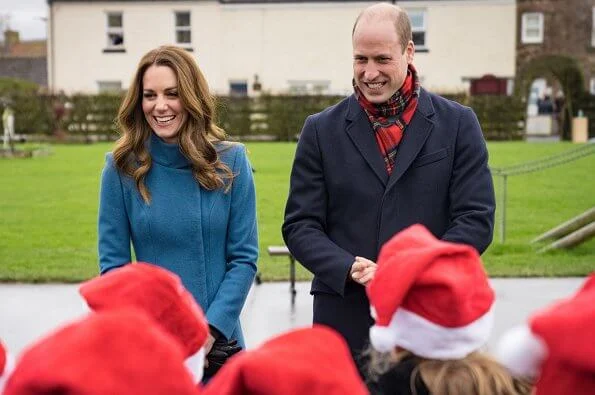 Kate Middleton wore a khaki coat and tartan scarf from Alexander McQueen, and blue coat and black gloves from Catherine Walker. Meghan Markle