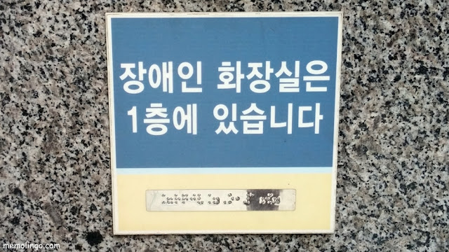 Cartel en coreano indicando la localización de los aseos para minusválidos