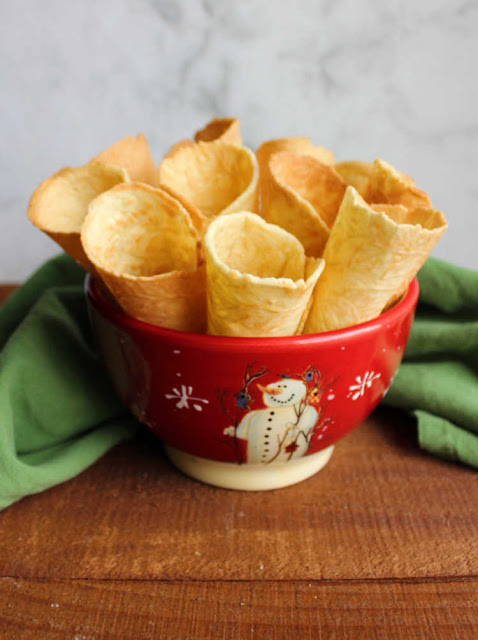 Scandinavian krumkake cookies are crunchy and delicious treats that are cooked on the stove instead of the oven. Fill them with whipped cream, fruit or frosting for an extra special dessert. bowl of crunchy krumkake horns
