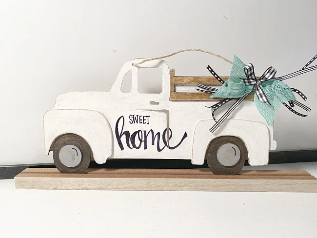 white distressed truck with a teal bow