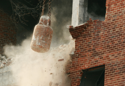wrecking ball busting a brick wall