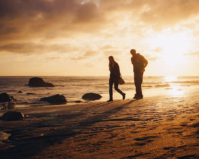 Couple Walking on the Beach during sunset.