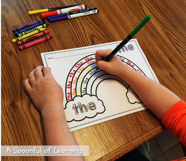 Using a green marker to write the word "the" on a rainbow